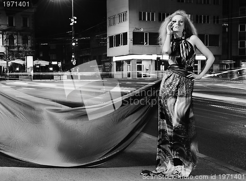 Image of elegant woman on city street at night