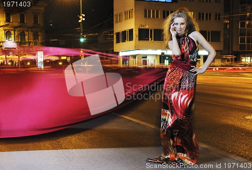 Image of elegant woman on city street at night