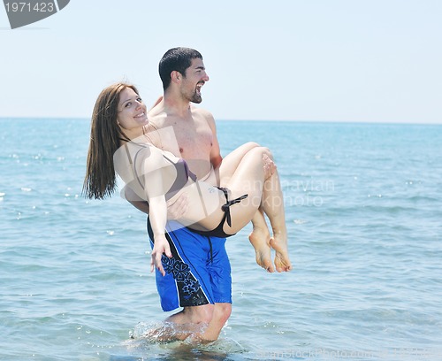 Image of happy young couple have romantic time on beach