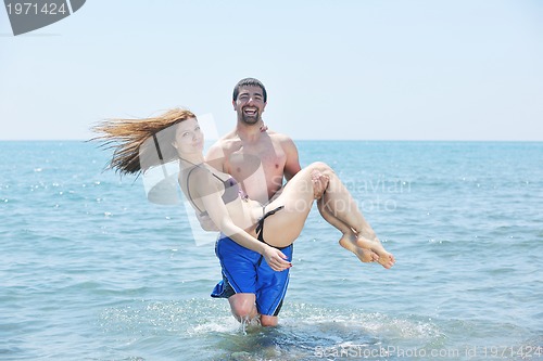 Image of happy young couple have romantic time on beach