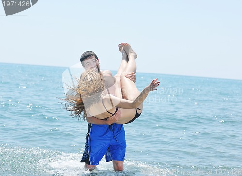 Image of happy young couple have romantic time on beach