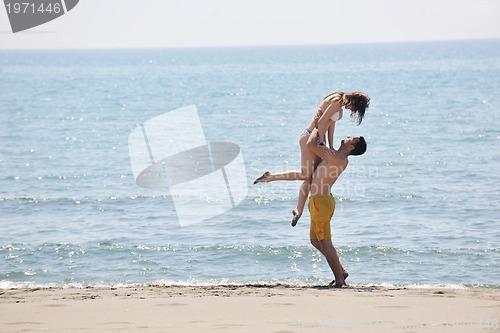 Image of happy young couple have fun on beach