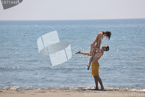 Image of happy young couple have fun on beach