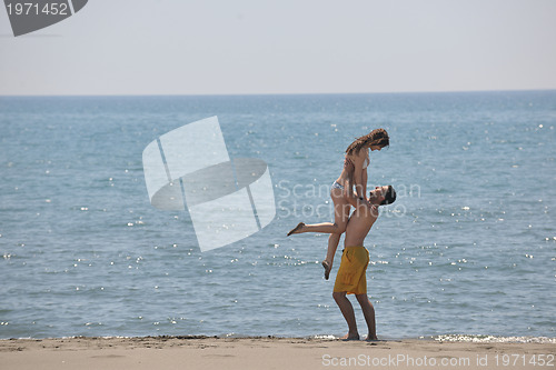 Image of happy young couple have fun on beach