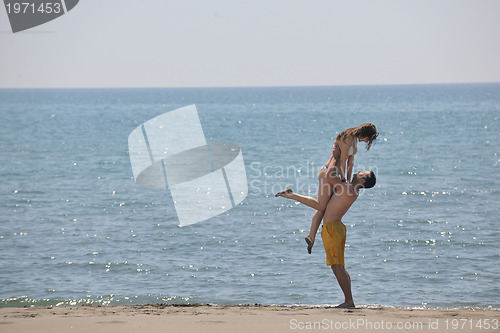 Image of happy young couple have fun on beach