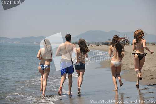 Image of happy people group have fun and running on beach