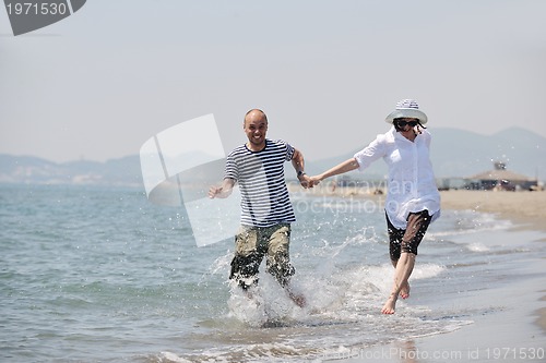 Image of happy young couple have fun on beach