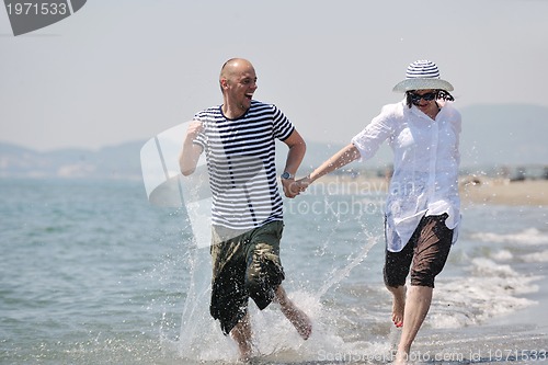Image of happy young couple have fun on beach
