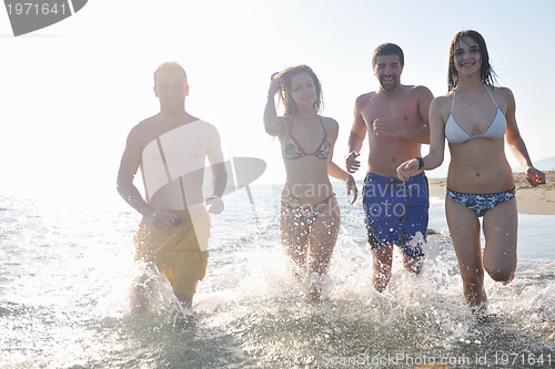 Image of happy people group have fun and running on beach
