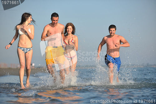 Image of happy people group have fun and running on beach
