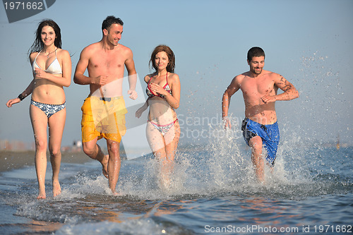 Image of happy people group have fun and running on beach