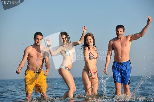 Image of happy people group have fun and running on beach