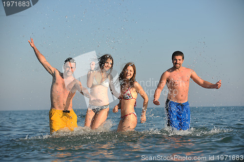 Image of happy people group have fun and running on beach