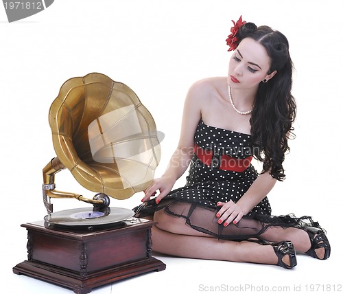 Image of pretty girl listening music on old gramophone