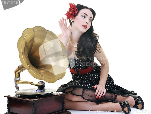 Image of pretty girl listening music on old gramophone