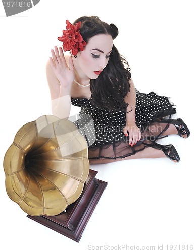 Image of pretty girl listening music on old gramophone