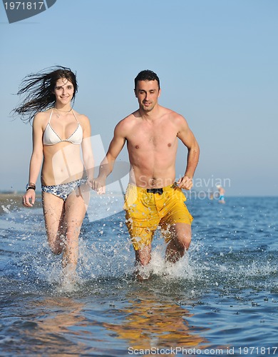 Image of happy young couple have romantic time on beach