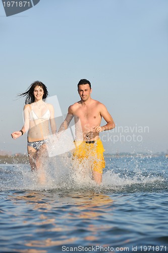 Image of happy young couple have fun on beach