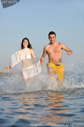 Image of happy young couple have fun on beach