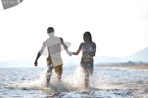 Image of happy young couple have fun on beach