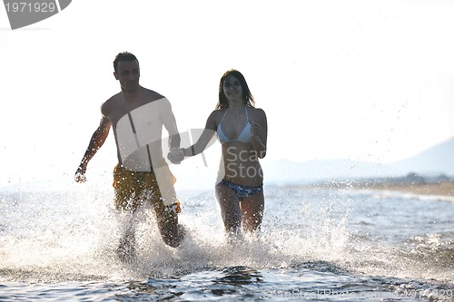 Image of happy young couple have fun on beach