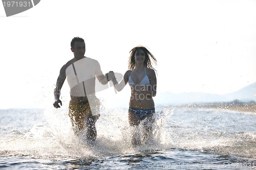 Image of happy young couple have fun on beach