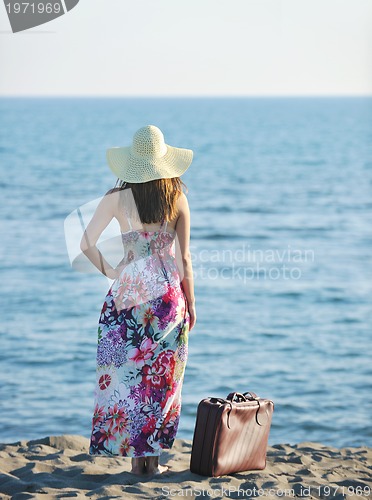 Image of woman with suitcase on the beach