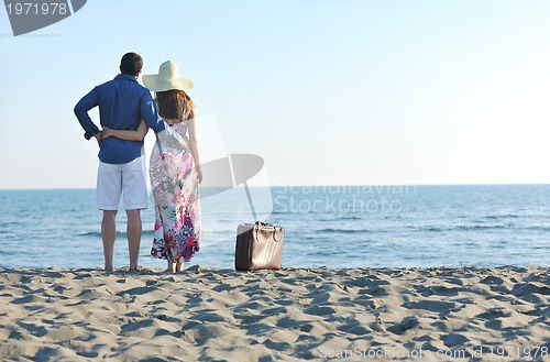 Image of couple on beach with travel bag