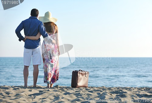 Image of couple on beach with travel bag