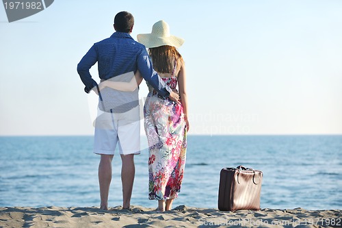 Image of couple on beach with travel bag