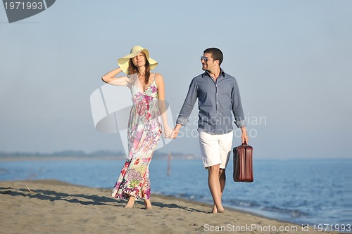 Image of couple on beach with travel bag