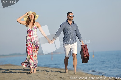 Image of couple on beach with travel bag