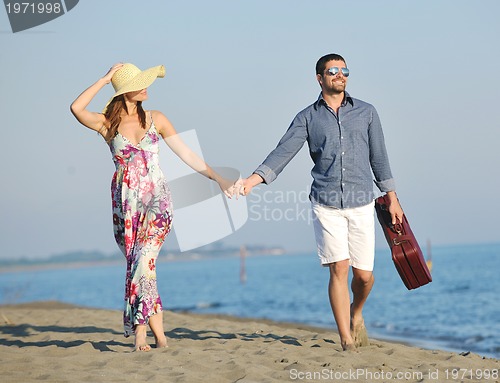 Image of couple on beach with travel bag