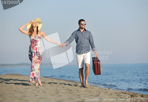 Image of couple on beach with travel bag