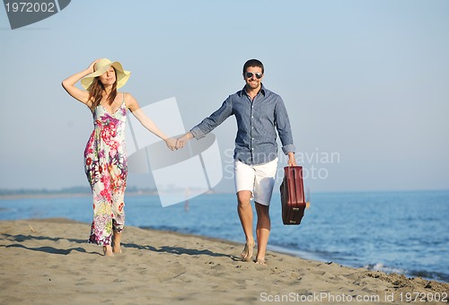 Image of couple on beach with travel bag