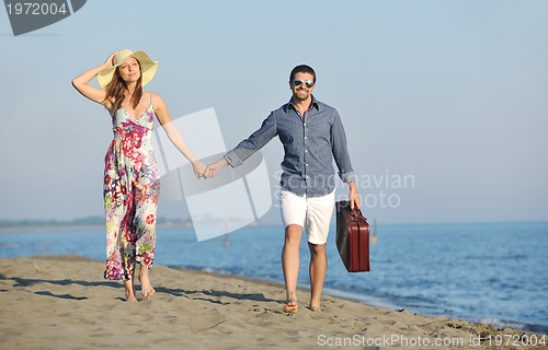 Image of couple on beach with travel bag