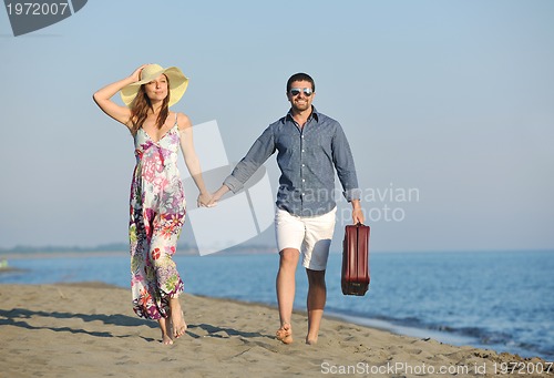 Image of couple on beach with travel bag