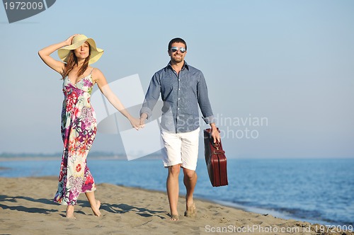 Image of couple on beach with travel bag