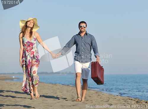 Image of couple on beach with travel bag
