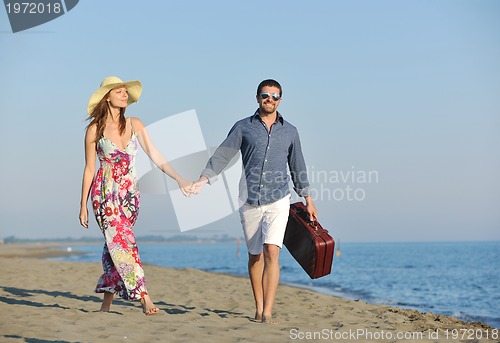 Image of couple on beach with travel bag