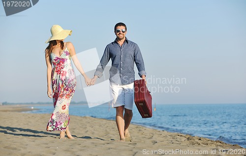 Image of couple on beach with travel bag