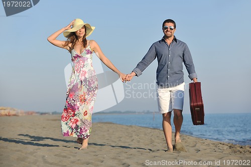 Image of couple on beach with travel bag