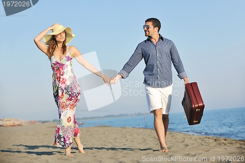 Image of couple on beach with travel bag