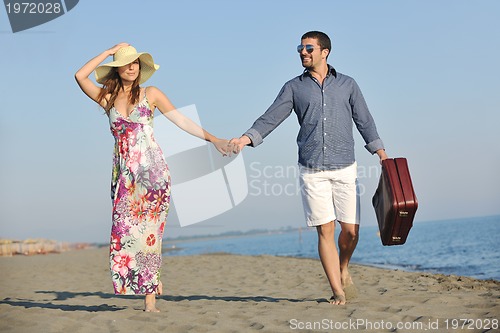 Image of couple on beach with travel bag