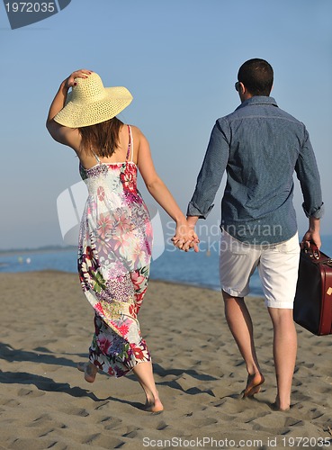 Image of couple on beach with travel bag