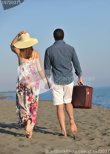 Image of couple on beach with travel bag