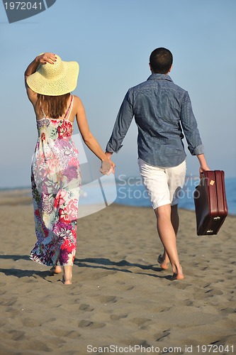 Image of couple on beach with travel bag