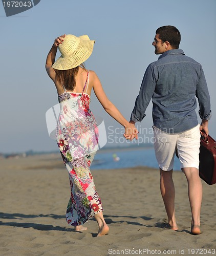Image of couple on beach with travel bag