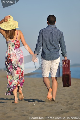 Image of couple on beach with travel bag