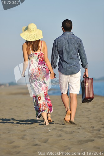Image of couple on beach with travel bag